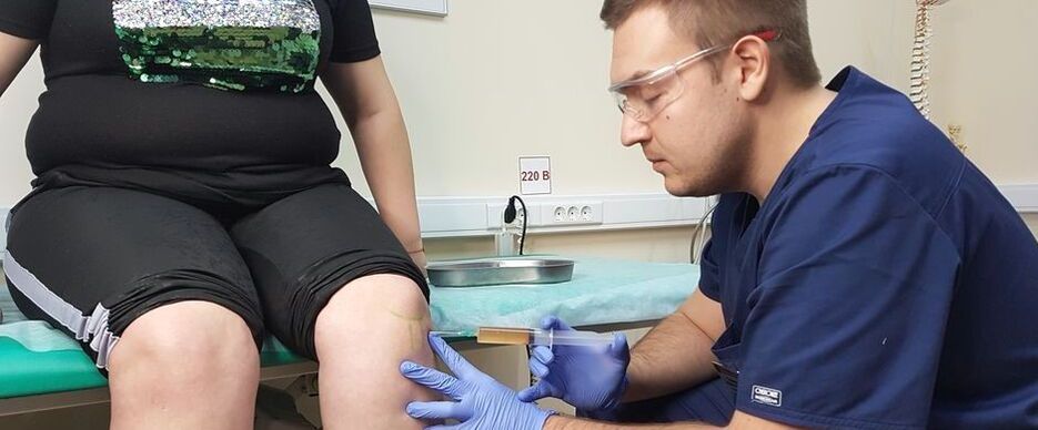 An orthopedic doctor performs an intra-articular injection into the knee joint for osteoarthritis