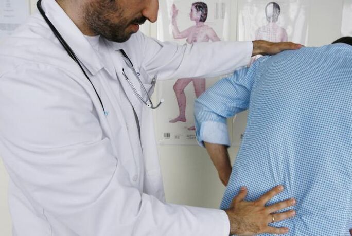 Doctor examining patient with back pain in lumbar region