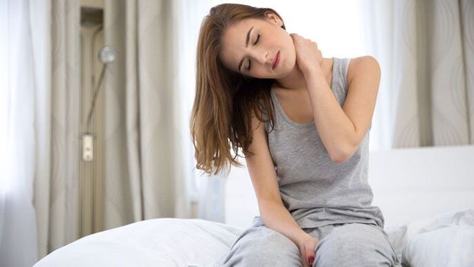 A woman feels a sharp pain in her neck.